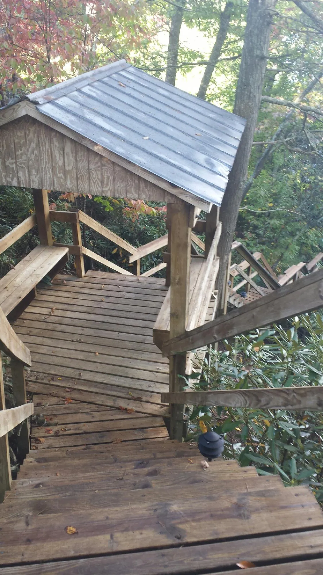 Metal roofed shelter over wooden steps on a wooded walkway — Skylight Repair & Installation work by our crew in New Providence